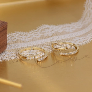 Macro shot of 14k gold plated ring featuring delicate pearls and crossed zircon pave rows