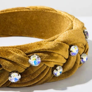 Detailed macro view of woven gold velvet headband with sparkling inlaid rhinestones