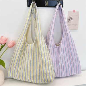 Close-up of colorful striped canvas tote bags with soft macaron tones and woven texture