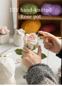 Detail showing the process of hand-knitting pink and white roses for a potted plant