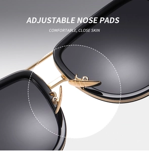 Close-up of adjustable nose pads and metal bridge on trendy black and gold sunglasses