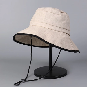 Close-up of cotton linen sun hat with black contrast brim and adjustable wind rope