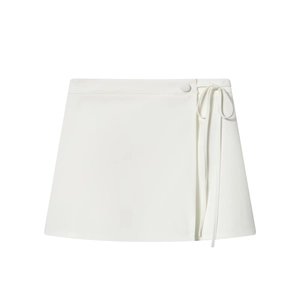Detail of white A-line wrap mini skirt featuring a side tie belt and matching button