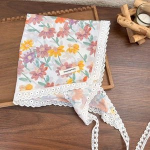 Detailed view of the 100% cotton label on a floral lace triangle headscarf