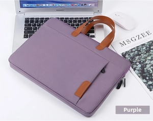 Gedetailleerde weergave van paarse 14-inch laptoptas met bruine lederen handvatten op bureau
