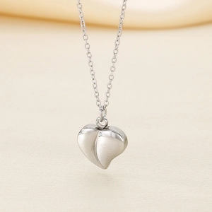Detail of silver heart pendant featuring matte finish and 3D polished metal texture