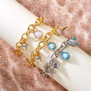 Starfish and shell pearl multi-pendant charm bracelets set on a beach sand background
