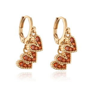 Macro detail of triple heart earrings with orange crystals in 18K gold plating