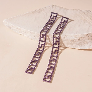 Macro shot of long purple crystal tassel earrings with geometric Greek key patterns