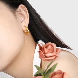 Elegant gold twisted hoop earrings with minimalist texture for women on model view