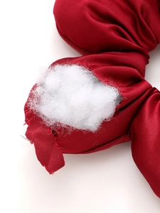 Close-up showing the soft cotton filling inside the red fabric hair scrunchie detail