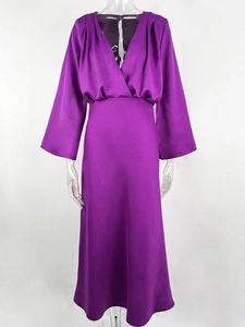 Detail of elegant deep purple V-neck maxi dress in glossy satin fabric with long sleeves
