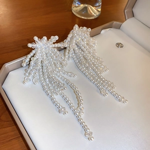 Vue détaillée des boucles d'oreilles à pampilles blanches avec design fleur élégant