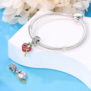 Detail of silver snake chain bracelet with Trick or Treat heart bead and red skull charm