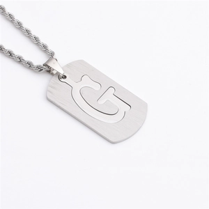 Gros plan du collier hip-hop argenté avec pendentif militaire en lettre G ajourée
