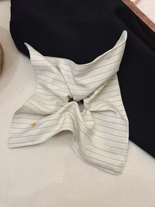 Detailed close-up of striped square scrunchie with a decorative gold button embellishment