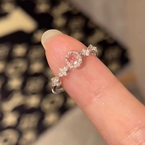 Detailed close-up of a pink solitaire ring with star accents on silver band