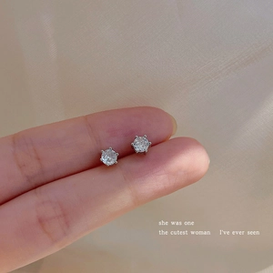 Close-up of sparkling cubic zirconia stud earrings with silver six-prong setting detail