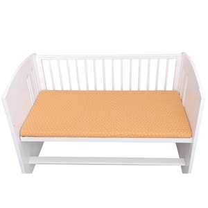 White wooden baby crib mattress cover with yellow polka dot print and wood frame
