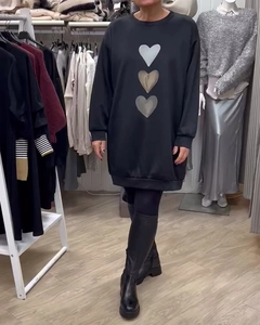 Detalle de tres corazones impresos en un vestido sudadera negro de manga larga