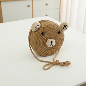 Détail d'un sac bandoulière en paille pour enfant en forme d'ours avec oreilles et sangle