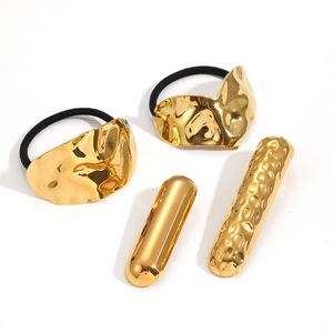 Détail de chouchous dorés à effet martelé et de barrettes cylindriques, ensemble de 4