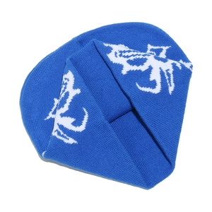 Dettaglio ravvicinato del berretto in maglia a coste blu con motivo astratto bianco