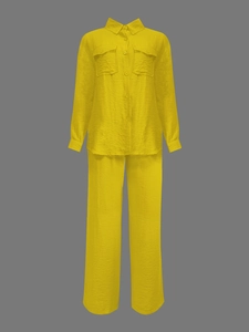 Detail view of bright yellow textured shirt set with chest pockets and matching wide-leg pants