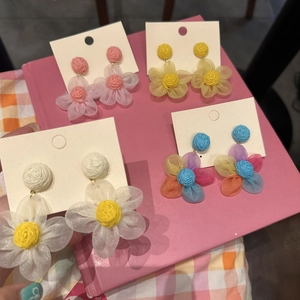 Pendientes de flores de rafia y tela hechos a mano en rosa, amarillo y varios colores.