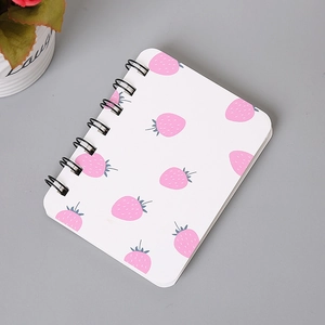 Detail of A7 spiral notebook featuring pink strawberry pattern and black wire-o binding
