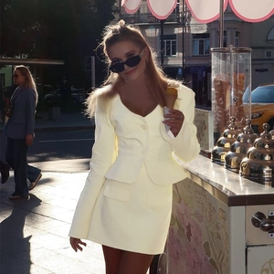 Detail view of butter yellow two-piece suit with slim fit blazer and matching mini skirt