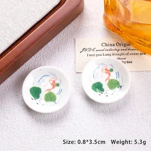 Detailed macro view of 3.5cm miniature ceramic plate with lotus and koi fish patterns