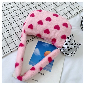 Detail of pink faux fur heart print handbag with a black and white polka dot bow