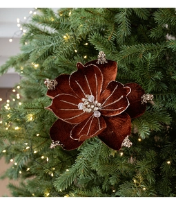 Close-up of velvet Christmas flower with gold glitter edges on a lighted tree