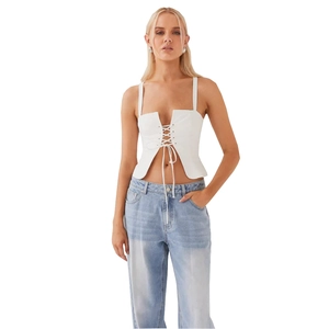 Top corto blanco con cordones y vaqueros azul claro para un estilo casual de verano