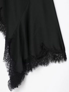 Détail d'une robe en satin noir avec bordure en dentelle délicate sur le décolleté