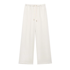 Detail of cream white wide leg trousers with elastic drawstring waist and metal tips