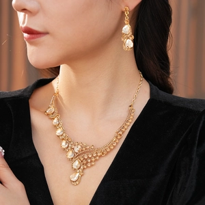 Gros plan sur l'ensemble collier en V et boucles d'oreilles aux strass champagne