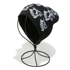 Detailed view of black knitted beanie with white jacquard street style letter pattern