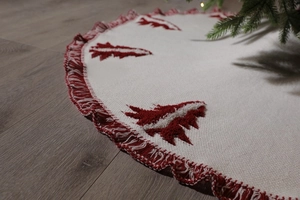 Close-up of knitted Christmas tree skirt with red fringe and cedar tree patterns
