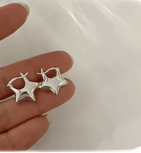 Dettaglio ravvicinato degli orecchini a cerchio a stella in argento lucido