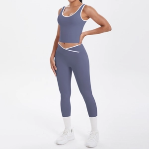 Detail of high-waist yoga leggings with V-shaped cross waistband and white contrast trim