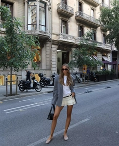 Estilo urbano a la moda de un conjunto de blazer gris y minifalda plisada blanca para mujer