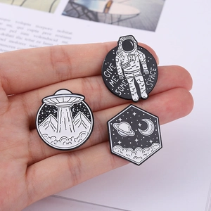 Space theme enamel pins set featuring astronaut, UFO and Saturn in minimalist black and white
