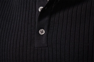Detail of black knitted Henley T-shirt showing vertical ribbed texture and buttons