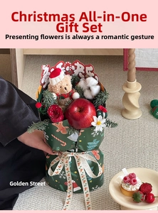 Detail of Christmas bouquet with teddy bear, red apple, and festive gingerbread wrapping paper