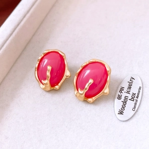 Detail of pink resin earrings with matte gold irregular edges in a vintage style
