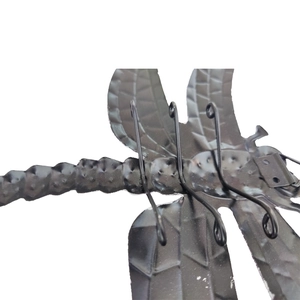 Detailed macro view of the textured black metal dragonfly wall decor showing wing patterns