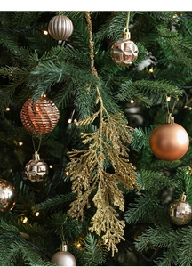 Golden glitter cypress leaves and assorted champagne gold ornaments on a Christmas tree