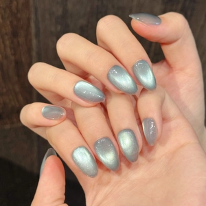 Ongles cat-eye vert menthe forme amande avec des reflets métalliques étincelants